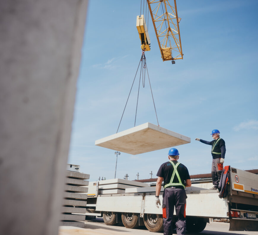 moll-rail-slowakia-crane-lowers-concrete-slab-onto-truck-under-supervision