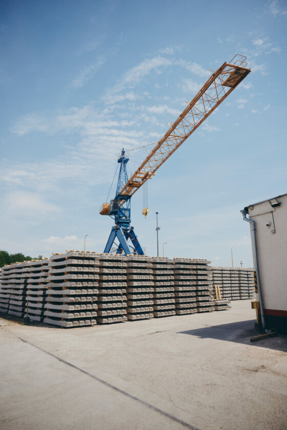 moll-rail-slowakia-industrial-crane-and-stacked-concrete-railway-sleepers-in-outdoor-storage-yard moll-rail-slowakia-industrial-crane-and-stacked-concrete-railway-sleepers-in-outdoor-storage-yard
