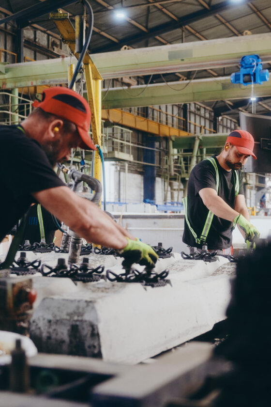 moll-rail-slowakia-two-workers-in-red-caps-assembling-concrete-sleepers-on-factory-production-line