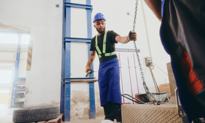 moll-rail-slowakia-worker-in-blue-hardhat-holding-chain-in-factory moll-rail-slowakia-worker-in-blue-hardhat-holding-chain-in-factory