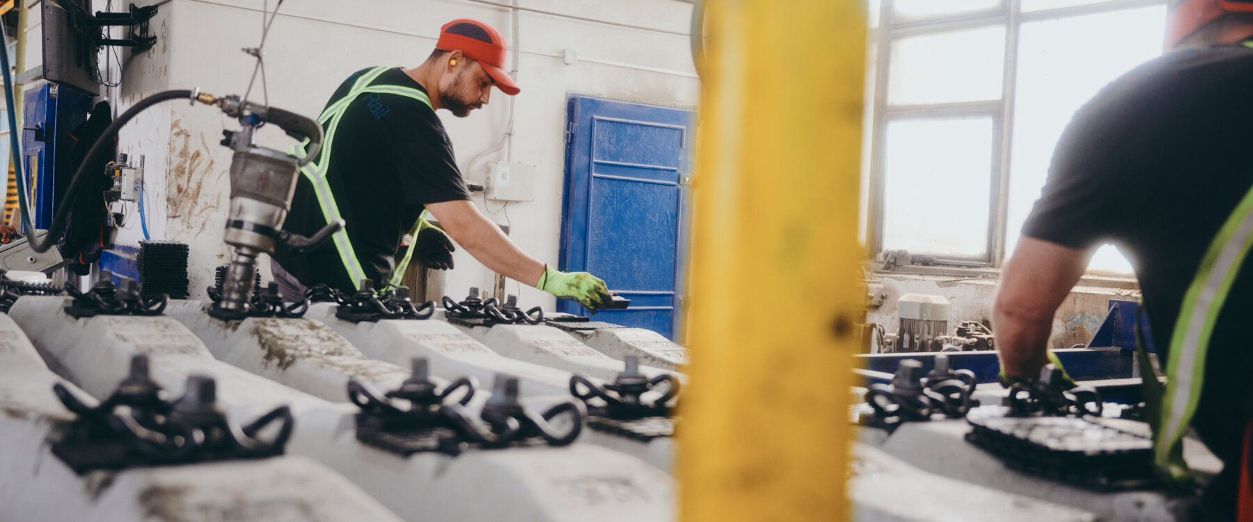 moll-rail-slowakia-worker-in-red-cap-assembling-fastenings-on-concrete-railway-sleepers-in-factory moll-rail-slowakia-worker-in-red-cap-assembling-fastenings-on-concrete-railway-sleepers-in-factory