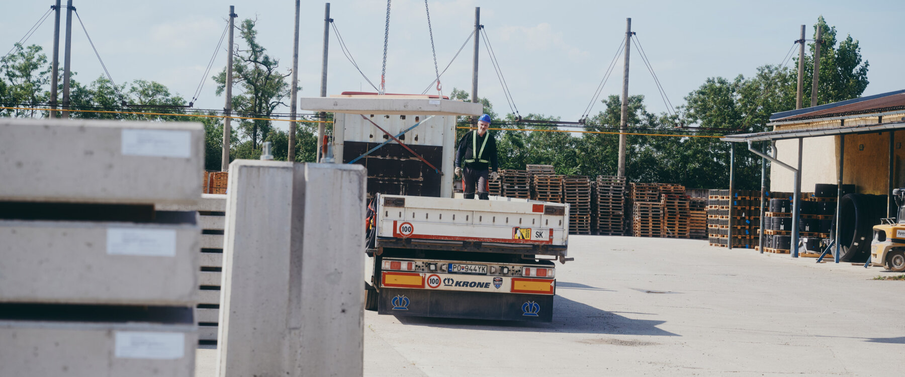 moll-rail-slowakia-worker-on-flatbed-trailer-guiding-concrete-elements-during-loading-in-storage-yard moll-rail-slowakia-worker-on-flatbed-trailer-guiding-concrete-elements-during-loading-in-storage-yard